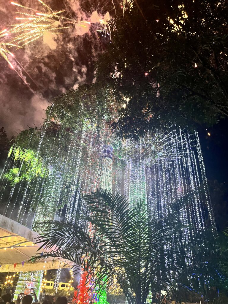 Golden and red fireworks bursting above the festive Christmas Village of Estancia de Lorenzo, creating a magical holiday atmosphere.